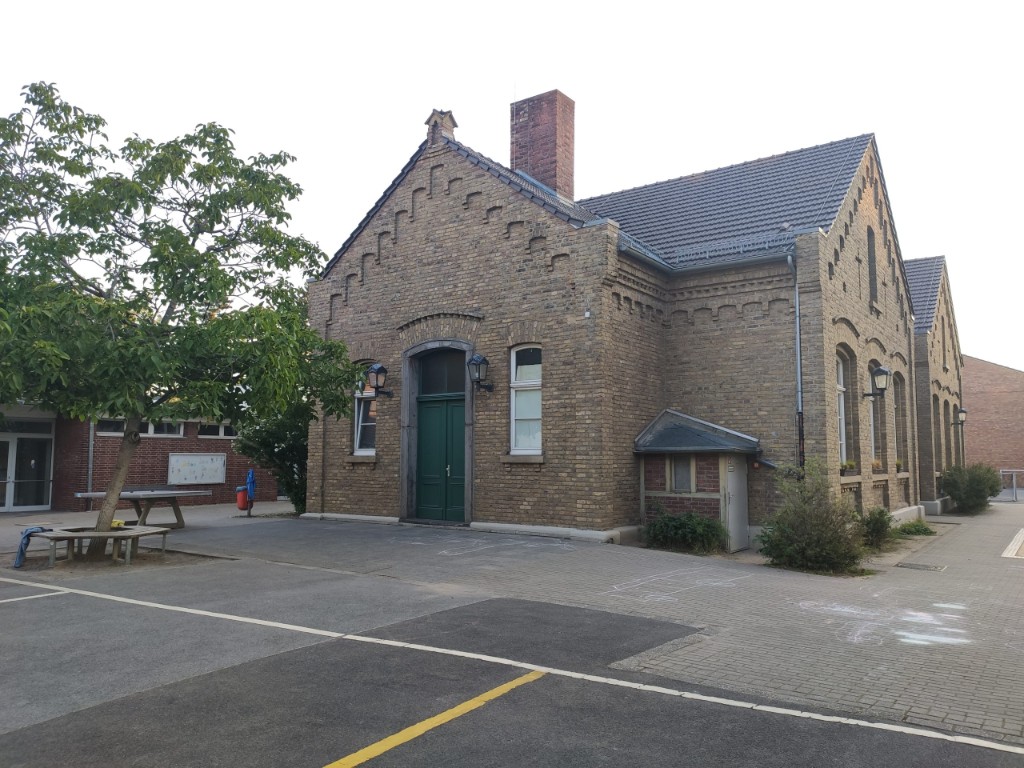 Katholische Grundschule Niederkassel – Schulhof und Schulgebäude im Frühling (Catholic primary school Niederkassel – schoolyard and building in spring)